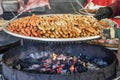 A pile of traditional, fresh German sausages over a charcoal grill on a christmas market