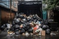 pile of trash bags surrounding an overfilled dumpster Royalty Free Stock Photo