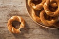 Pile Turkish bagel Simit in a plate and bitten bagel on wooden background