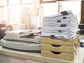 Pile of unfinished business documents on office desk