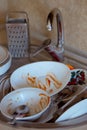 Pile of unwashed, dirty dishes in the sink. Mess in the kitchen. Dirty kitchenware, plates and mugs