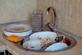 Pile of unwashed, dirty dishes in the sink. Mess in the kitchen. Dirty kitchenware, plates and mugs