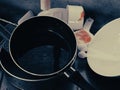 Pile of unwashed dirty pots, dishes and plastic container in sink after cooking or baking. Domestic untidy kitchen