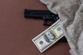 Pile of US dollar cash and a black pistol gun. Seen from above. Royalty Free Stock Photo