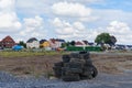 A pile of used car tires lies in a vacant lot. In the background there are residential houses Royalty Free Stock Photo