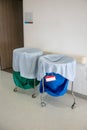 A pile of used clothes and infectious substances in hospital movable trolley with green bag and blue bag. Royalty Free Stock Photo