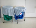 A pile of used clothes and infectious substances in hospital movable trolley with green bag and blue bag. Royalty Free Stock Photo