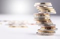 Pile of various coins stacked on an imbalanced column