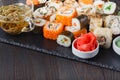 Pile of Various kinds of sushi served on black stone