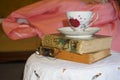 Pile of vintage books with a delicate vintage teacup and saucer on top Royalty Free Stock Photo