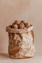 A pile of walnuts in a brown paper bag on a beige background Royalty Free Stock Photo