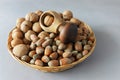 a pile of walnuts and hazelnuts in a braided plate on a gray background Royalty Free Stock Photo