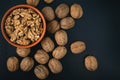 Pile of walnuts and peeled nuts in bowl. Royalty Free Stock Photo