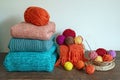Pile of warm knitted sweaters and colorful balls of wool Royalty Free Stock Photo