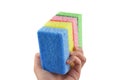 A pile of washing sponges (yellow, green pink and blue) in a hand Royalty Free Stock Photo