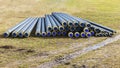 A pile of water pipes with thermal insulation in a meadow Royalty Free Stock Photo