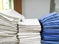 Pile of white and blue cloth, towel, bedspread, bedsheet in the hospital, with blur white background