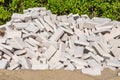 Pile of white bricks is on the yellow sand on the green plants background Royalty Free Stock Photo