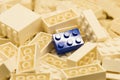 Pile of white color building blocks with selective focus and highlight on one particular blue block using available light Royalty Free Stock Photo