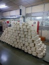 A pile of white cotton yarn bobbin put on table in textile spinning plant