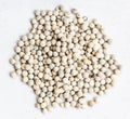 Pile of white pepper peppercorns close up on gray Royalty Free Stock Photo