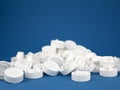 Pile of white plastic screw caps on the blue background. Closures made from renewable polymers. Concept of waste sorting and Royalty Free Stock Photo
