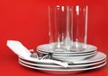 Pile of white plates, glasses, forks, spoons. Royalty Free Stock Photo