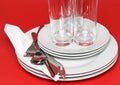 Pile of white plates, glasses, forks, spoons. Royalty Free Stock Photo