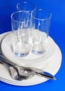 Pile of white plates, glasses, forks, spoons. Royalty Free Stock Photo