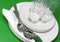 Pile of white plates, glasses, forks, spoons. Royalty Free Stock Photo