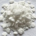 A pile of white potassium hydroxide flakes on a textured surface Royalty Free Stock Photo