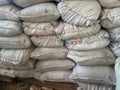 a pile of white sacks containing fermented fertilizer with manual stitching