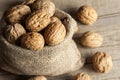 Walnut kernel with thin shell in burlap sack on wooden vintage rustic backdrop. Fresh walnuts background concept Royalty Free Stock Photo