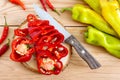 A pile of whole and chopped pepper on a wooden table. Hot and sweet green, orange, red peppers. Rustic style. Top view.A pile of Royalty Free Stock Photo