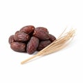 pile of whole dates next to a single, long, dry palm leaf segment Royalty Free Stock Photo
