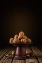 A pile of whole dried walnuts in a clay bowl against a brown backdrop with a vignette on a table made of old boards. moody Royalty Free Stock Photo