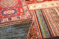 pile of wollen Persian rugs for sale in the shop specializing in