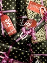 Stacked wrapped and decorated Christmas gifts with cute tags