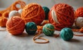 A pile of yarn balls in various colors, including orange, green, and white, are laid out on a table. Royalty Free Stock Photo