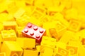 Pile of yellow color building blocks with selective focus and highlight on one particular red block using available light Royalty Free Stock Photo