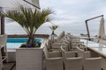 Piled on each other wicker chairs near the pool on sea promenade