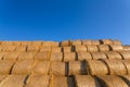 Piled hay bales on a field against blue sky Royalty Free Stock Photo