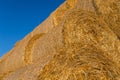 Piled hay bales on a field against blue sky Royalty Free Stock Photo