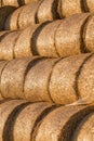 Piled hay bales on a field against blue sky Royalty Free Stock Photo