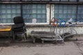 Piled old dirty dusty office chairs, stacked cargo trolleys and a rusty weathered yellow metallic table Royalty Free Stock Photo