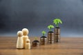 Piles of coins are stacked in a graph shape with family symbol and sapling of a growing tree Royalty Free Stock Photo