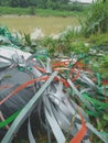 Piles of colorful plastic rope rubbish are scattered on the edge of a river Royalty Free Stock Photo