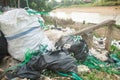 Piles of colorful plastic rope rubbish are scattered on the edge of a river Royalty Free Stock Photo