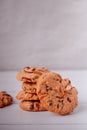 Piles of delicious chocolate chip cookies on a white plate with a milk bottle. Pastry utensils with white linen napkins on a woode Royalty Free Stock Photo