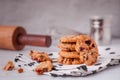 Piles of delicious chocolate chip cookies on a white plate with a milk bottle. Pastry utensils with white linen napkins on a woode Royalty Free Stock Photo